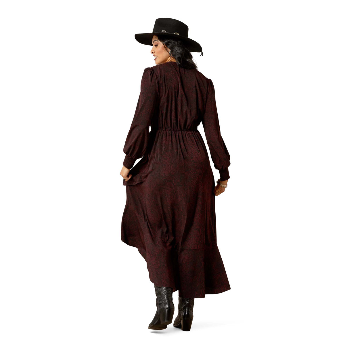 Woman wearing a long brown dress with a black hat on a white background