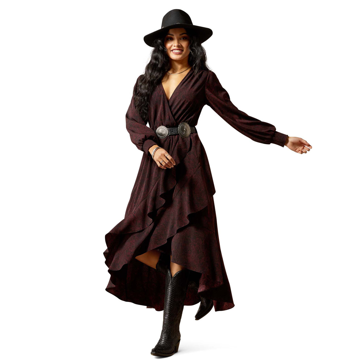 Woman wearing a long brown dress with a belt and black boots on a white background