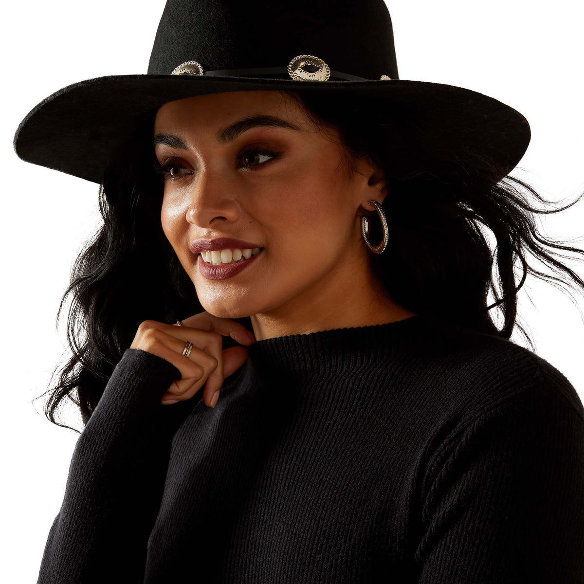 Woman wearing a black hat and black outfit against a white background