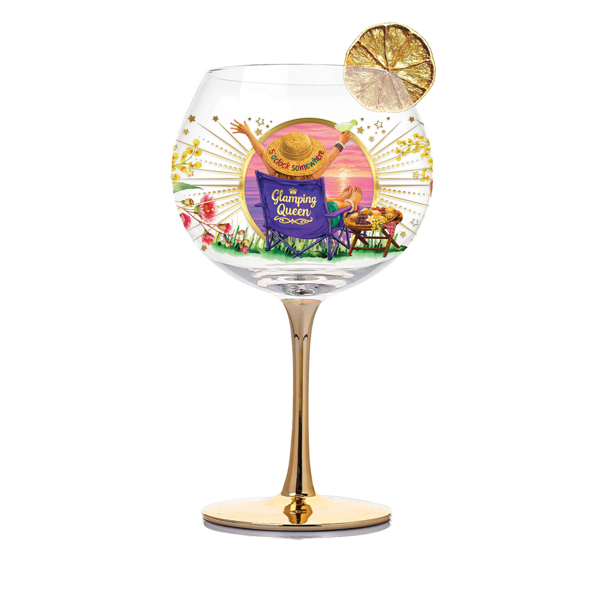 A clear glass cocktail glass with a gold stem and base, decorated with a colorful 'Glamming Queen' illustration and a gold citrus wheel garnish, on a white background.