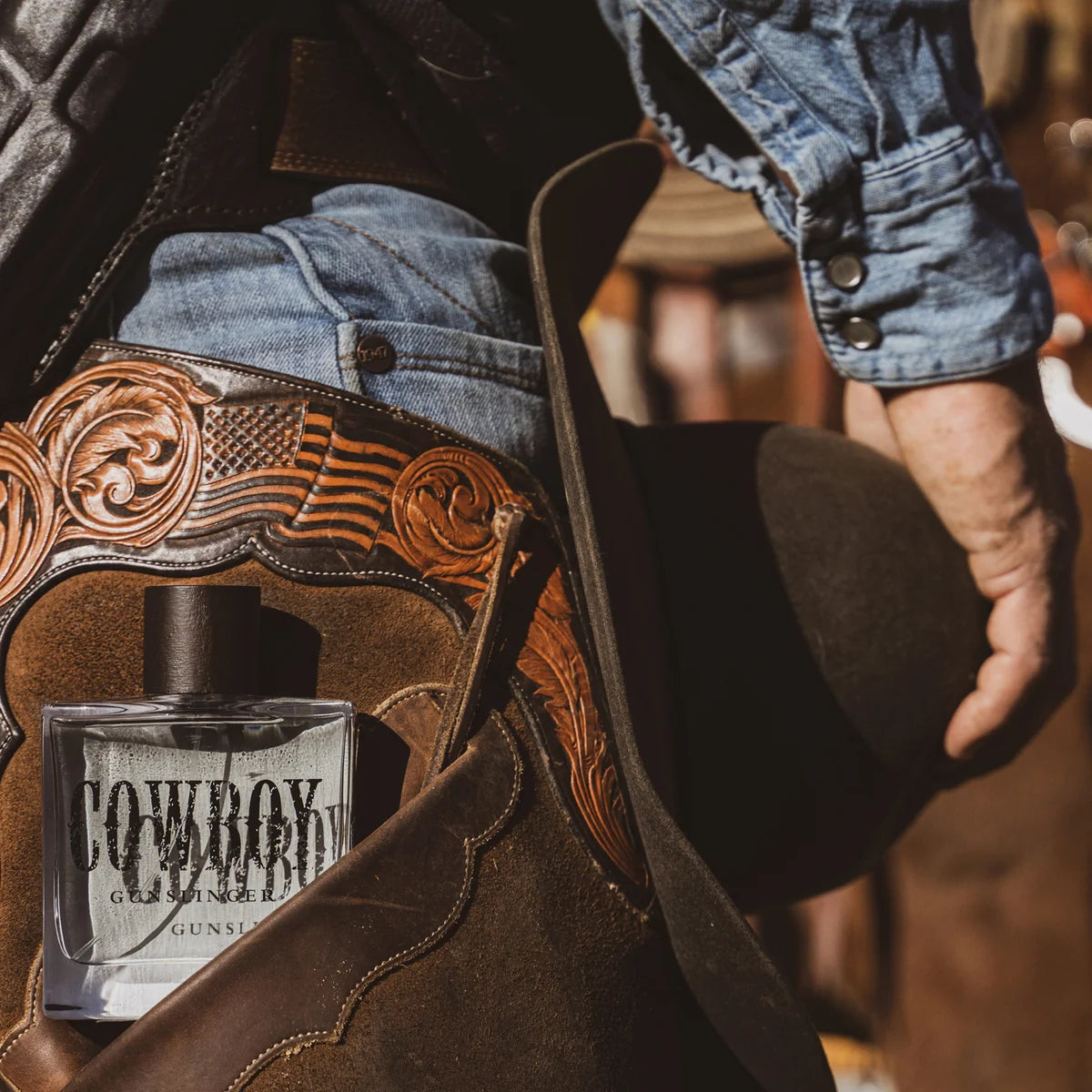 Cowboy boot with decorative在美国国旗图案, holding a bottle of 'Cowboy' cologne.