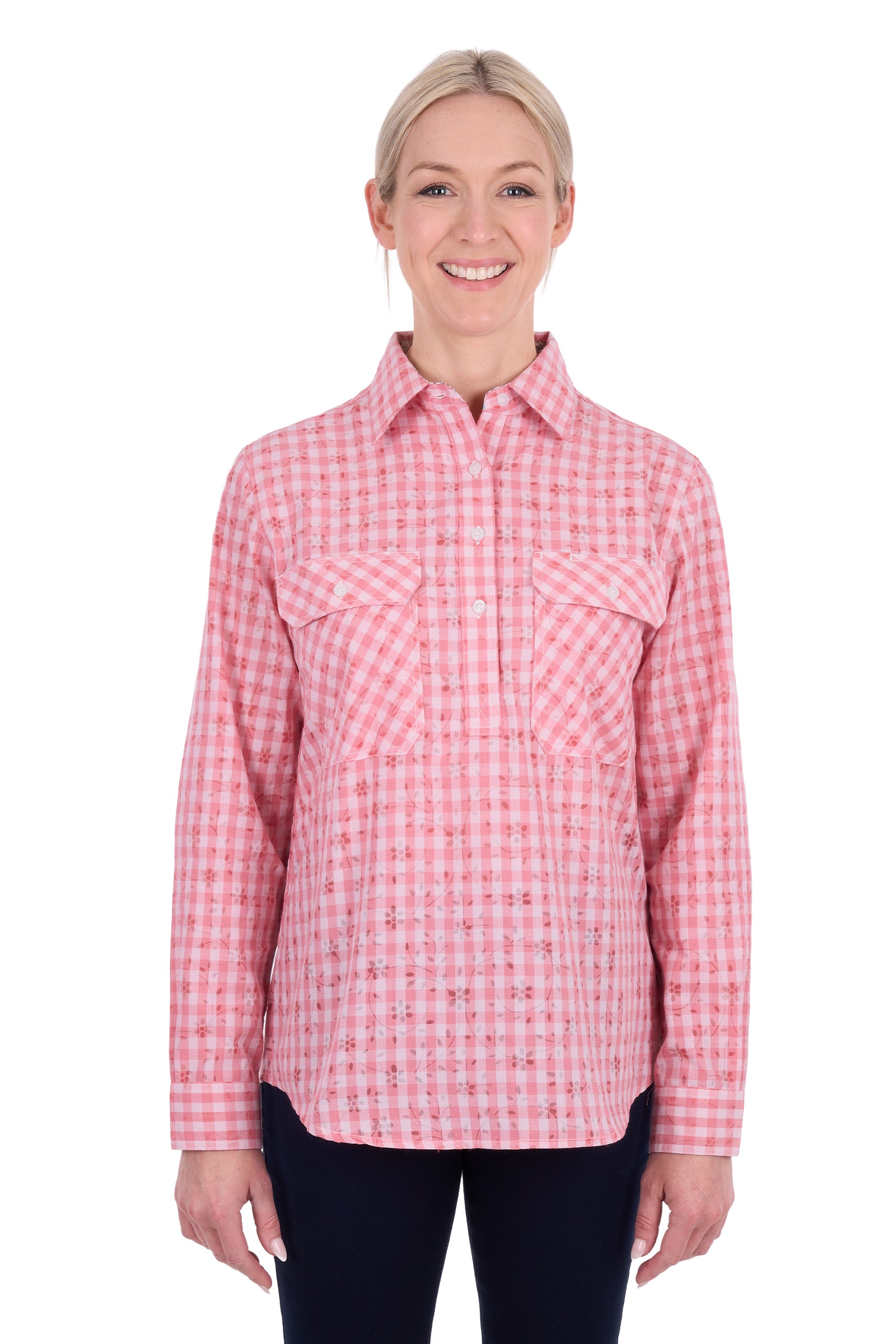 A woman modeling a pink and white gingham long-sleeve button-up shirt with two chest pockets, paired with dark pants, against a plain white background.