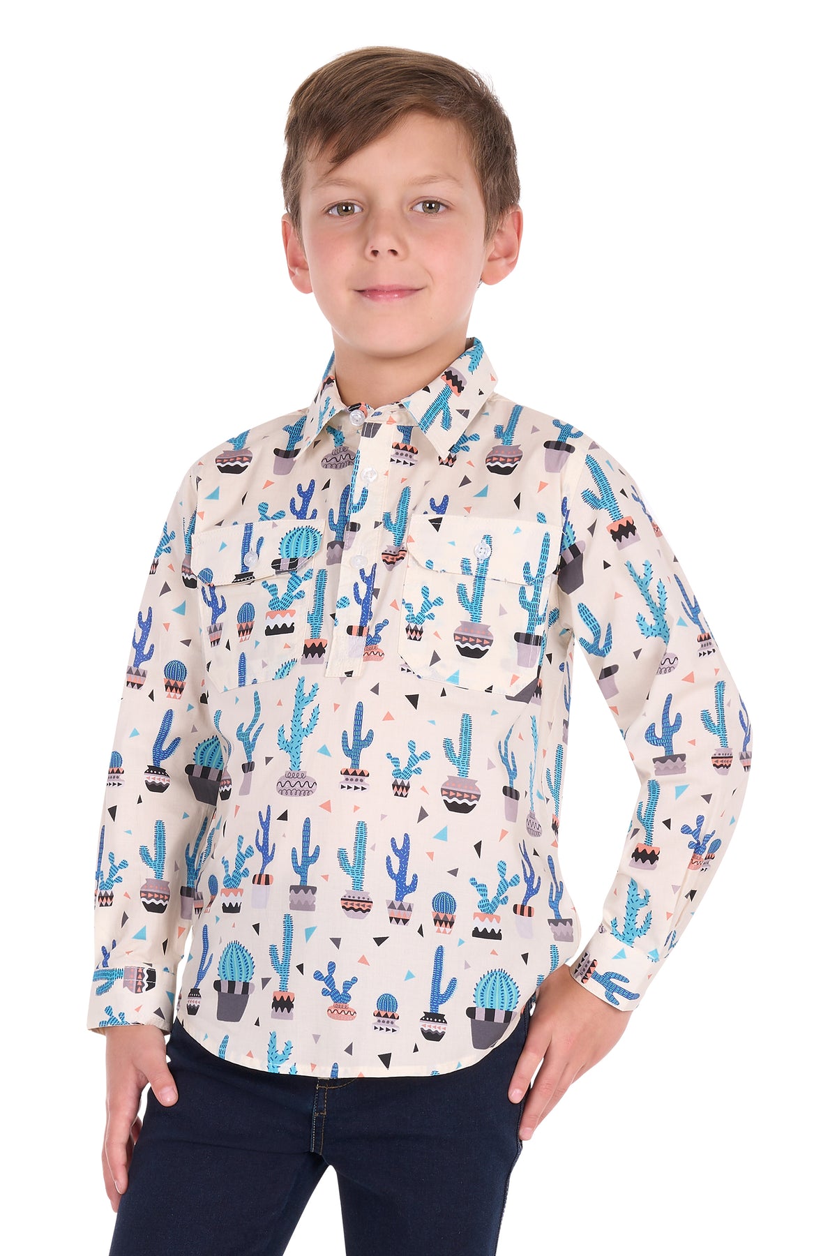 A young boy modeling a long-sleeve button-up shirt with a colorful desert cactus pattern, paired with dark blue jeans, against a plain white background.