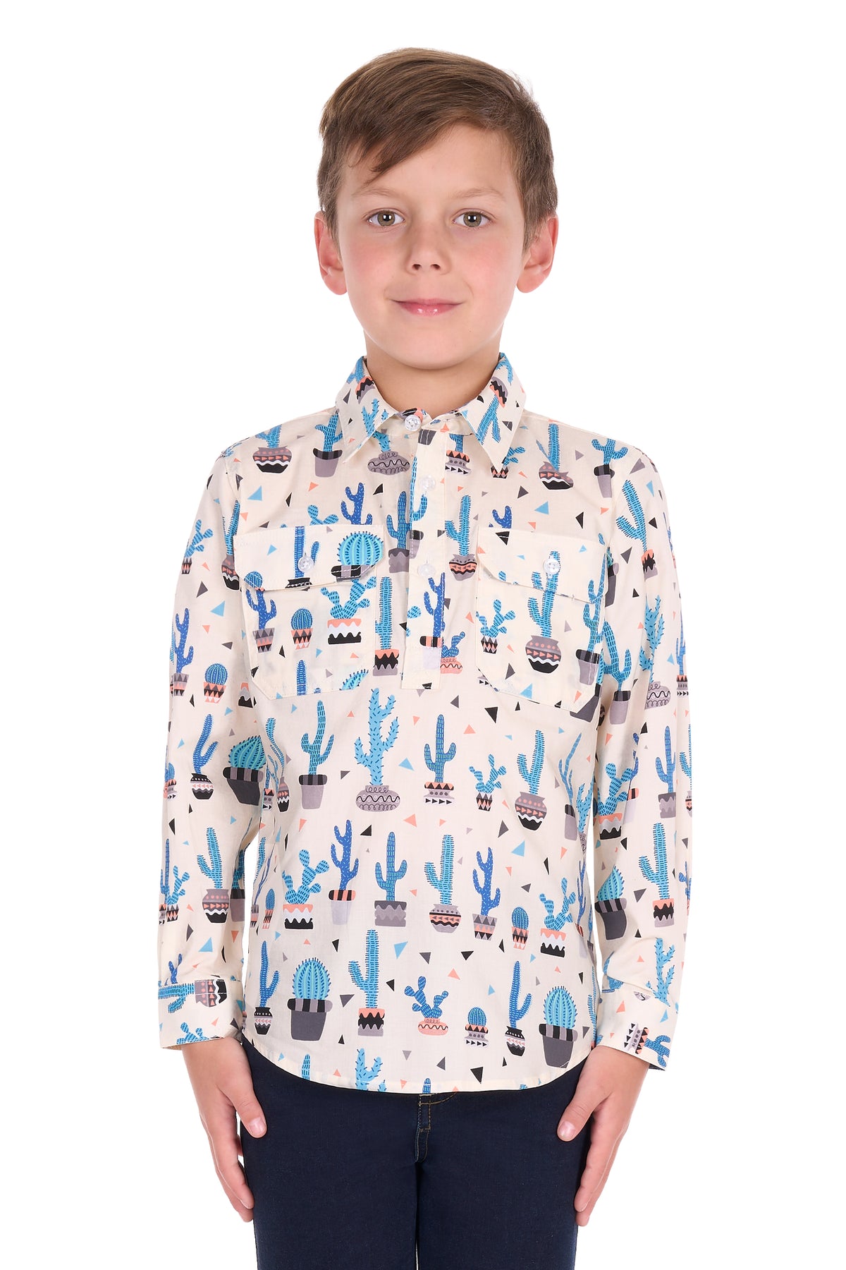 A young boy wearing a long-sleeve button-up shirt with a colorful cactus and succulent pattern on a cream background, paired with dark blue pants, photographed against a solid white background.
