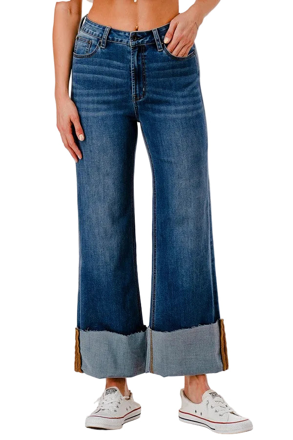 Person wearing blue wide-leg jeans with a white background