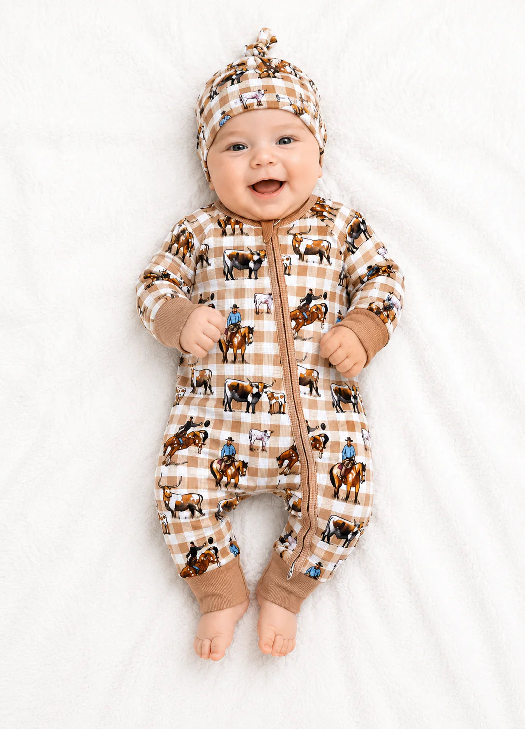 Baby wearing a checkered romper with horse patterns on a white background