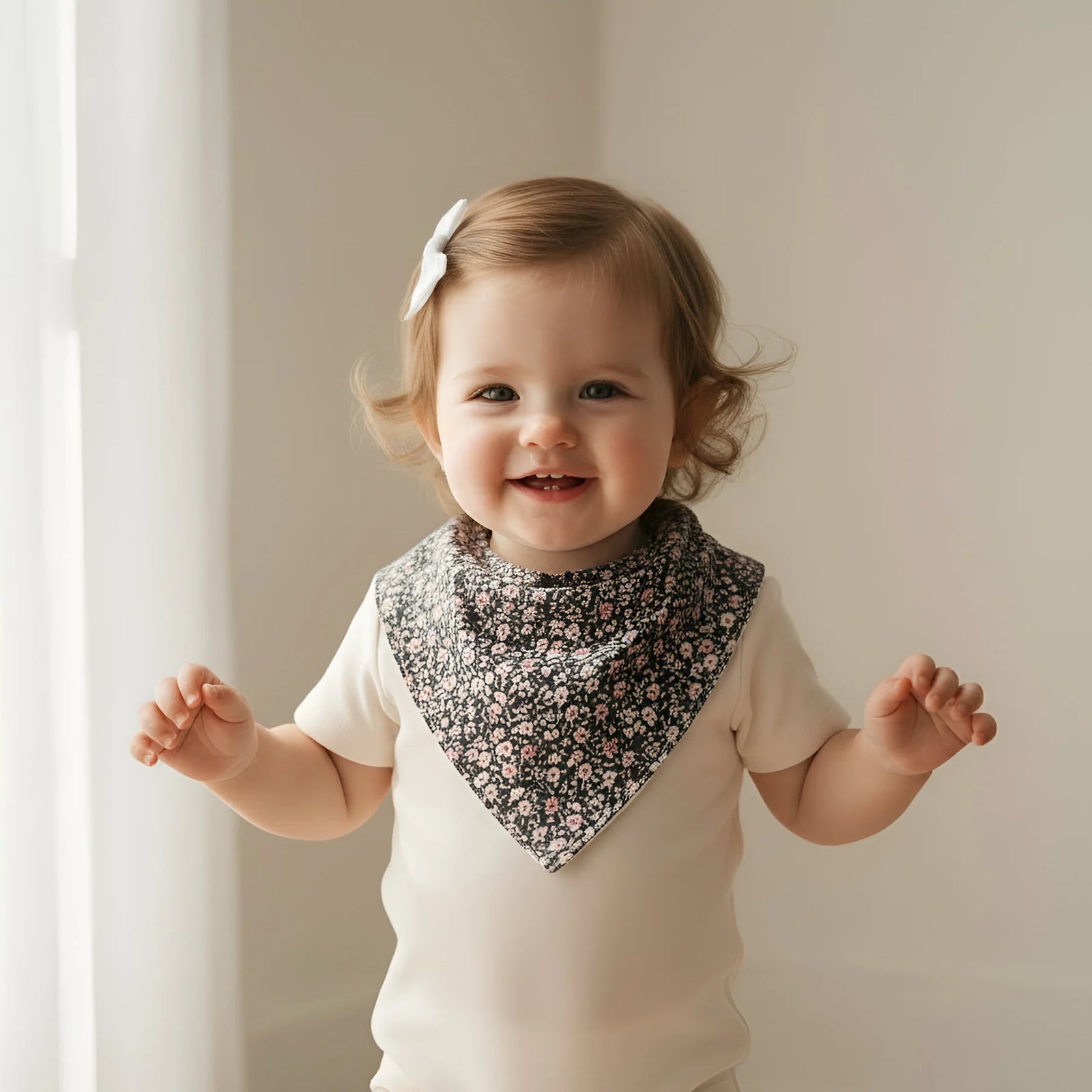 Child wearing a floral bib against a neutral background