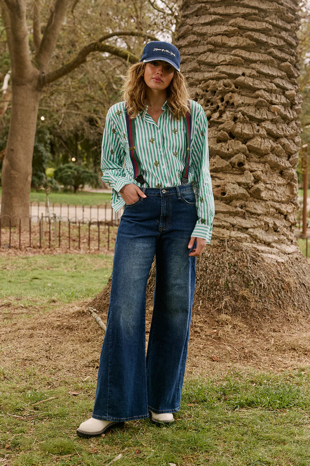 Italian Star Women's Stripe Cactus Shirt. Person wearing a striped shirt, suspenders, and jeans standing in a park.
