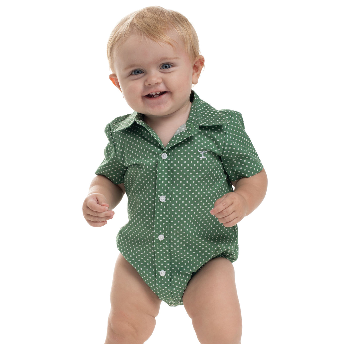 Baby wearing a green polka dot onesie on a white background