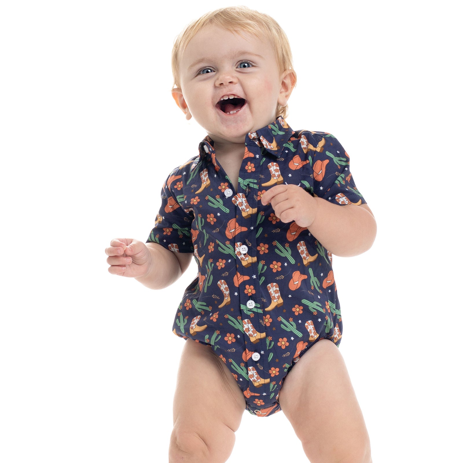Baby wearing a navy blue romper with cowboy print on a white background