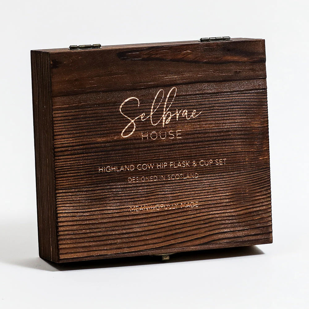 A dark brown wooden presentation box with engraved text reading 'Selbrae HOUSE' and 'Highland Cow Hip Flask & Cup Set' on a clean white background.