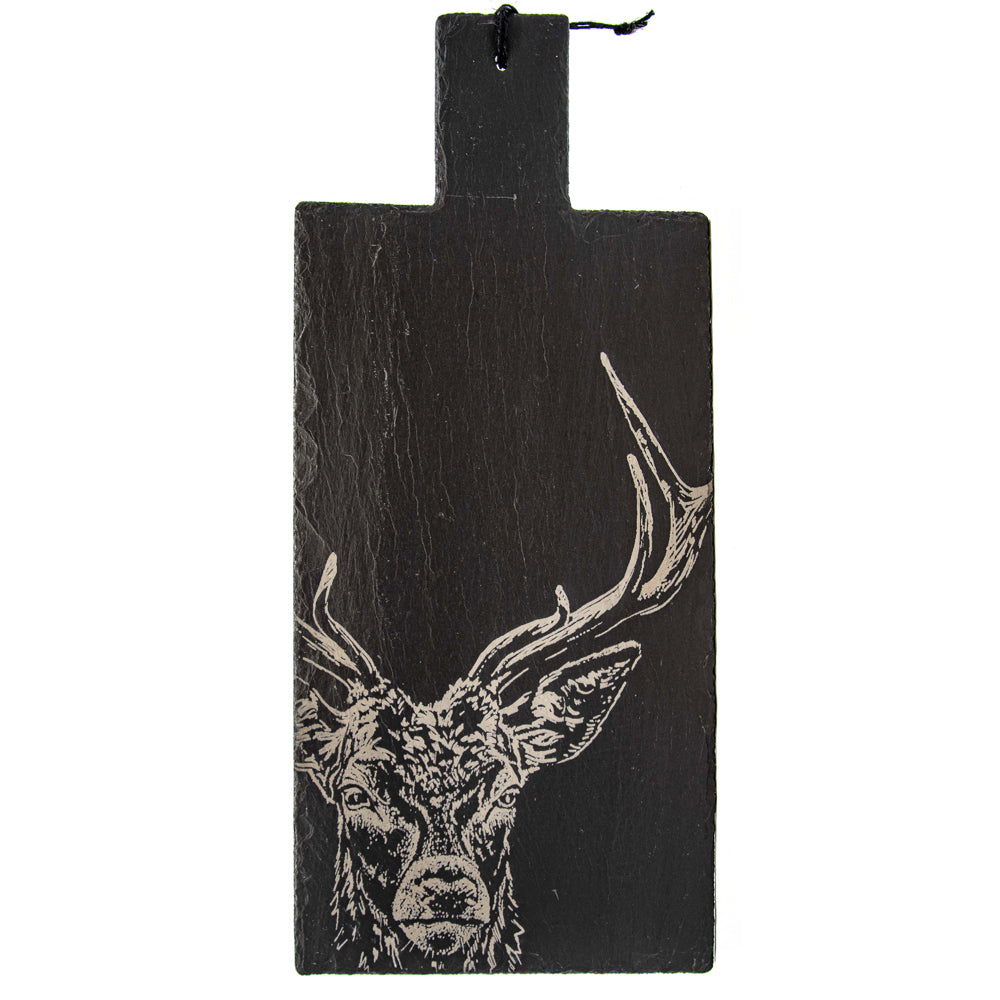 A dark charcoal gray rectangular slate cutting board with a hanging loop at the top, featuring a white engraved line art illustration of a deer head with large antlers.