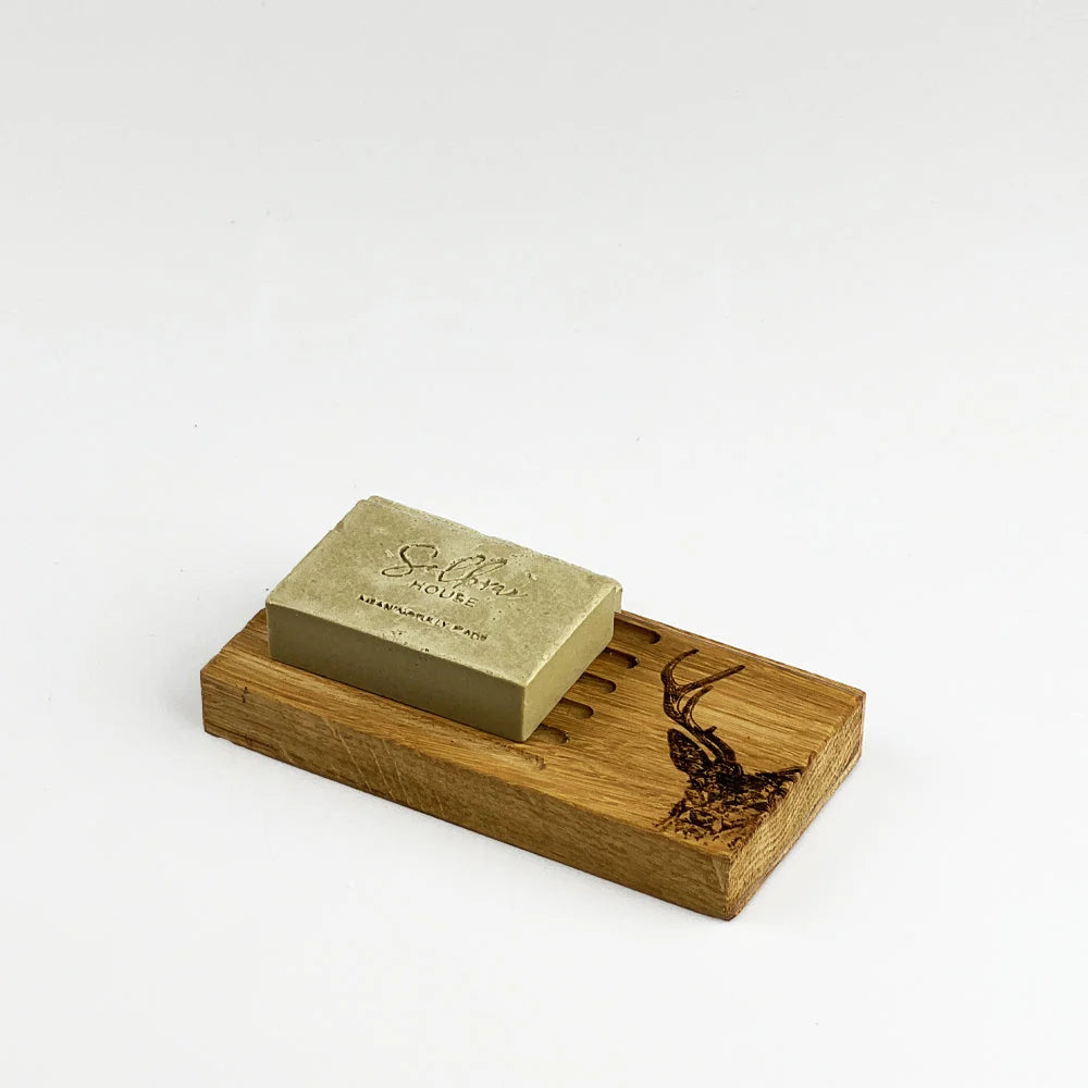 Gold soap bar on a wooden soap dish with 'Sable' branding on a white background