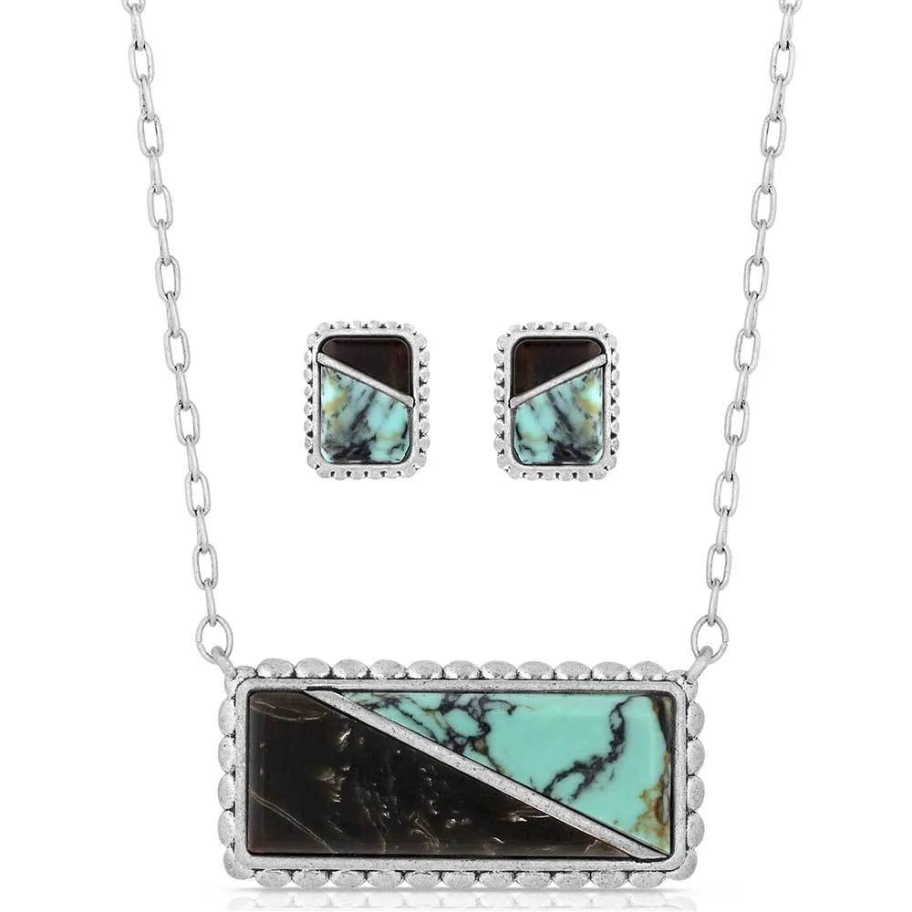 Necklace and earrings set with turquoise and black stone inlays on a white background