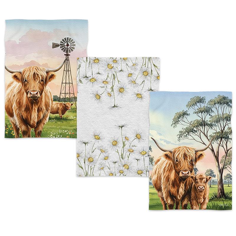 Three decorative towels featuring Highland cows and nature scenes on a white background.