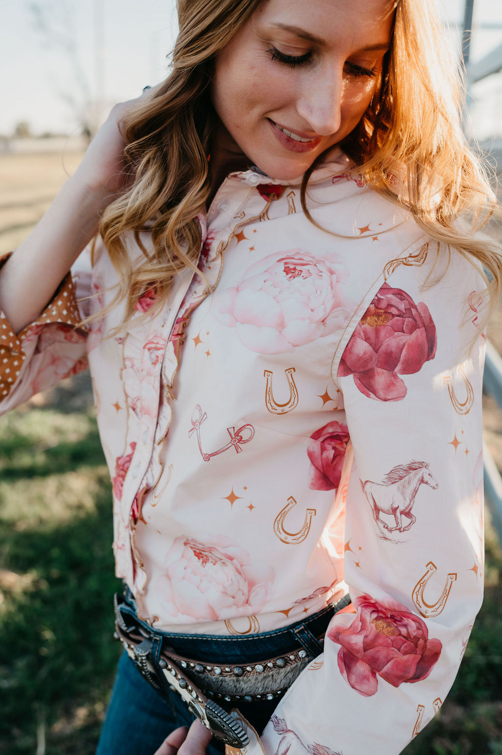 Kitty Fordè Lisa Printed L/S Shirt. Woman wearing a floral blouse with a patterned sleeve in an outdoor setting