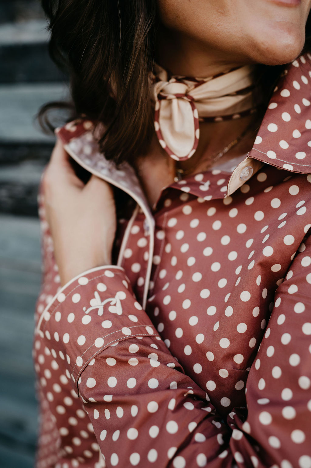 Kitty Fordè Petrina Printed L/S Shirt. Person wearing a red polka dot shirt with a scarf and earrings.