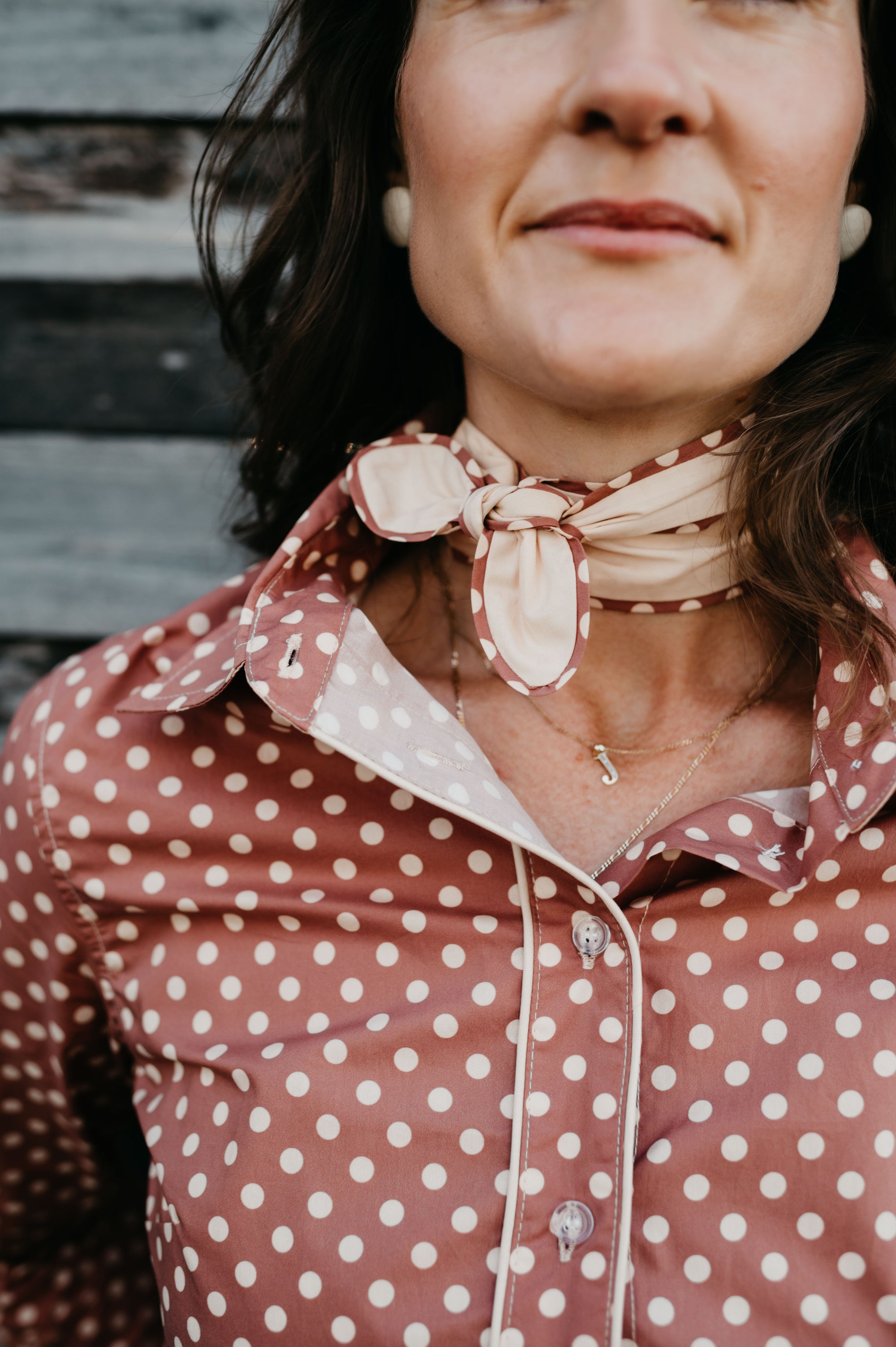 Kitty Fordè Spots Printed Necktie. Woman wearing a red polka dot blouse with a beige scarf tied around her neck.