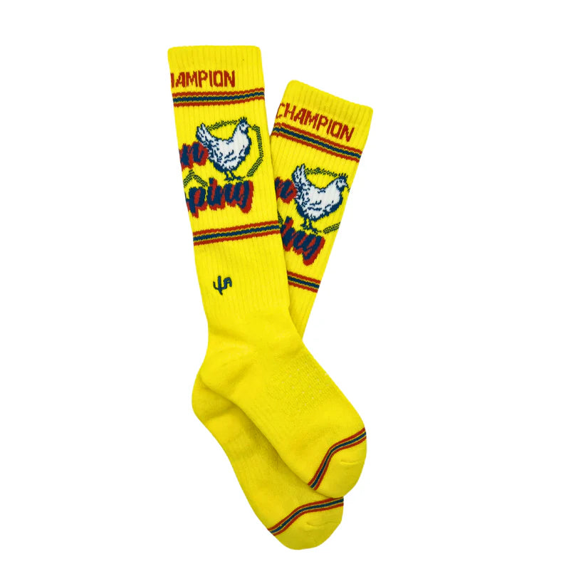 Lucky Chuck Cactus Alley Chicken Roping Performance Socks. Yellow socks with chicken graphic and 'Champion' text on a white background