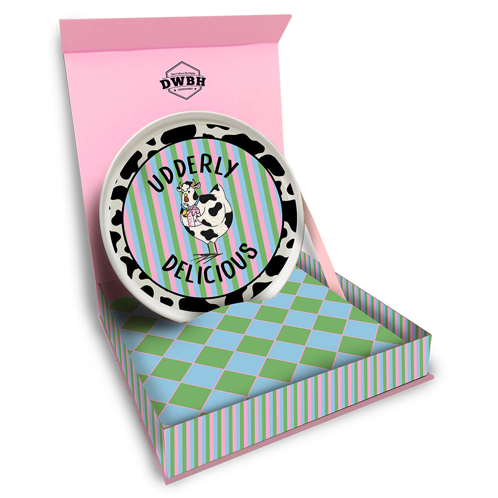 Decorative plate with cow design and 'Udderly Delicious' text in a colorful box.