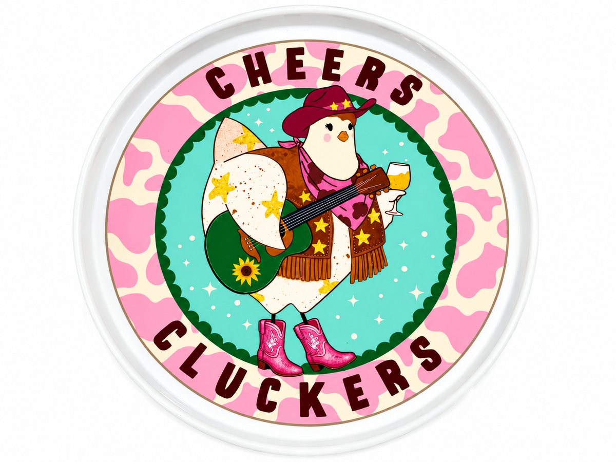 A round white decorative tray featuring a colorful printed design with the words 'CHEERS CLUCKERS' around a cartoon chicken dressed in western clothing and holding a guitar and mug.