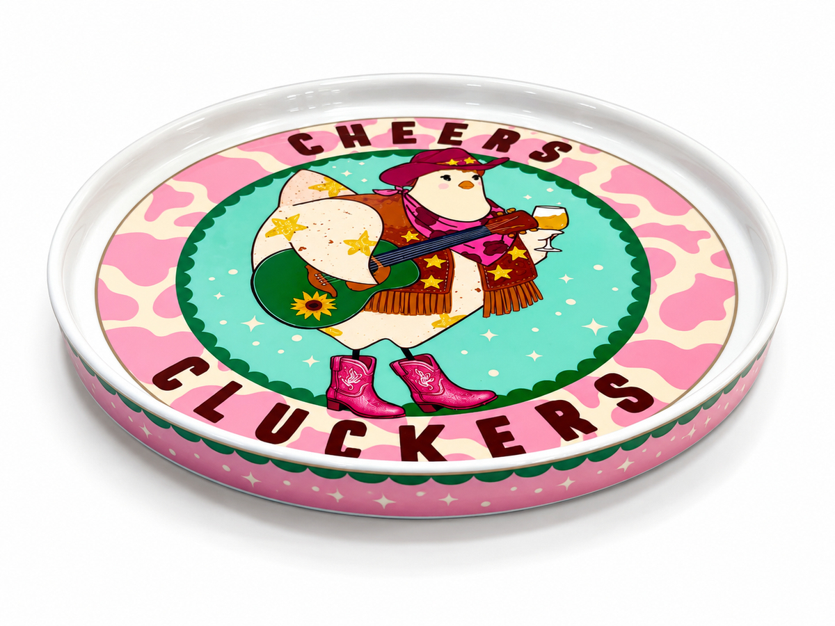 A round ceramic serving tray with a whimsical western-themed illustration. The design features a cartoon penguin wearing a red hat, brown scarf, and pink boots while playing a guitar.