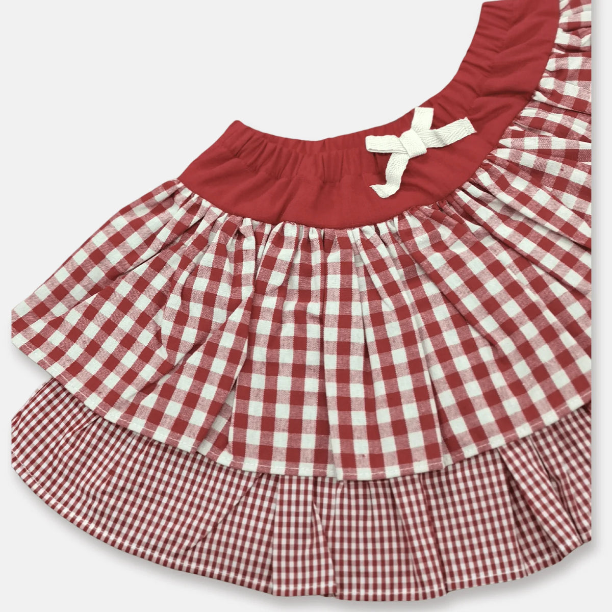 Love Henry Girl's Frilly Skirt. A girl's frilly skirt with a red and white checkered pattern and a solid red color at the bottom, featuring an elasticated waistband.
