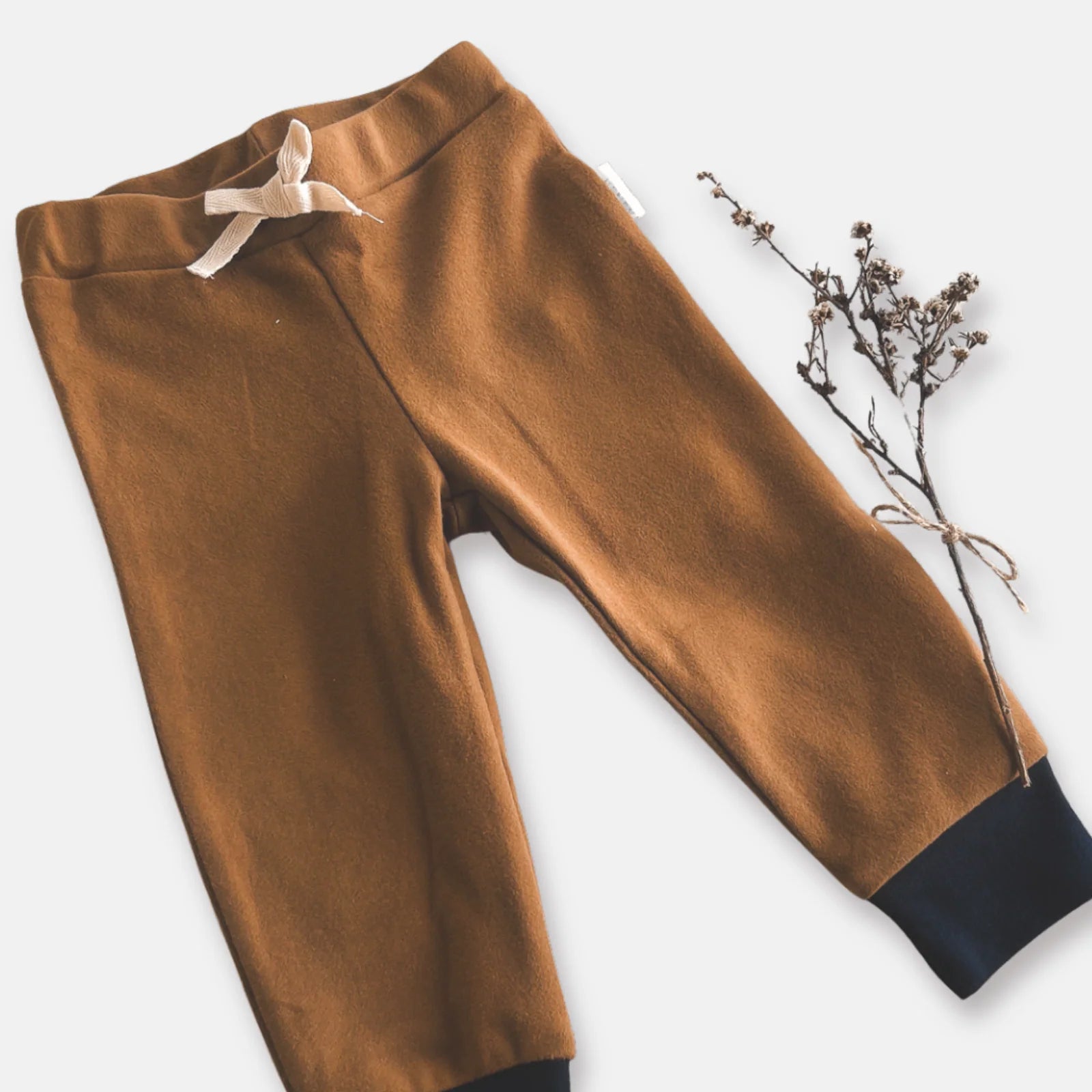Love Henry Baby Boy's Comfy Pants. Brown children's pants with a bow on a light gray background