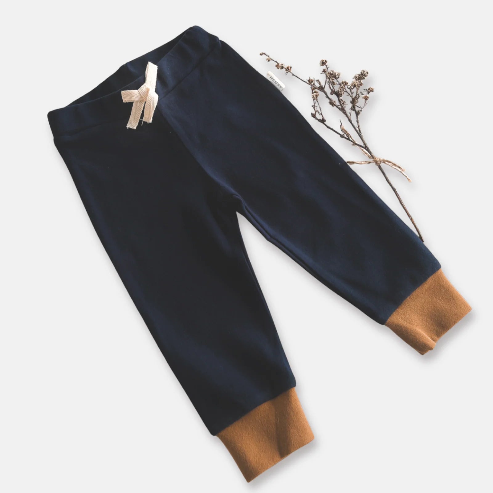 Love Henry Baby Boy's Comfy Pants. Navy blue pants with brown cuffs on a white background