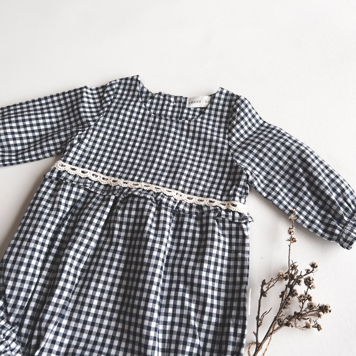 Love Henry Baby Girls L/S Nora Playsuit - Navy Check. Navy and white checkered dress with a chain detail on a white background