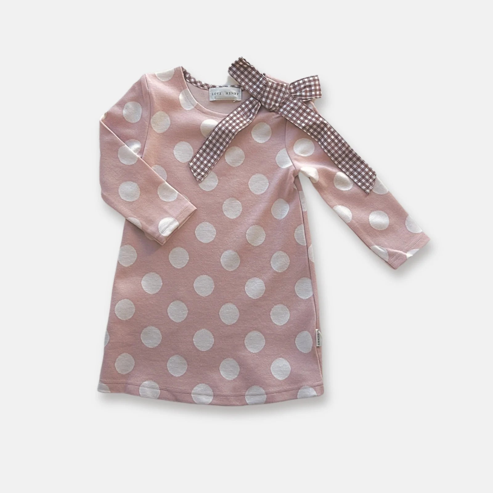 Love Henry Girl's Mary Dress. Pink dress with white polka dots and checkered bow on a light background