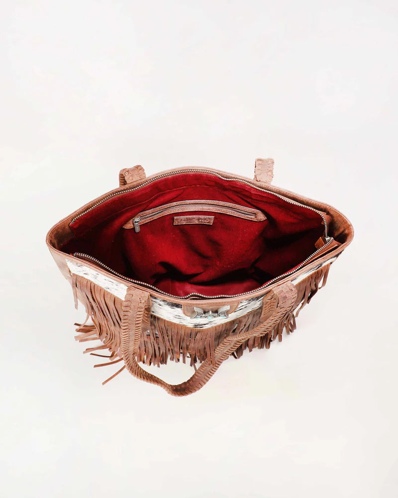 Loyal West Hide And Fringe Large Cowhide Western Handbag. Brown handbag with fringe details on a white background