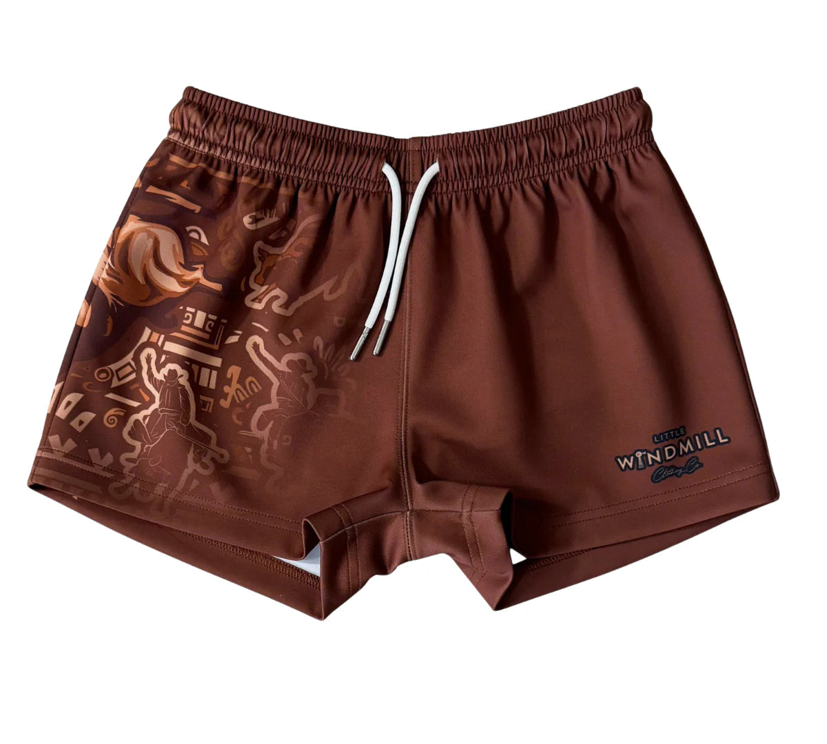 Little Windmill Dust Scene Bull Footy Shorts. Person wearing brown shorts with a pattern and visible brand logo, standing outdoors.