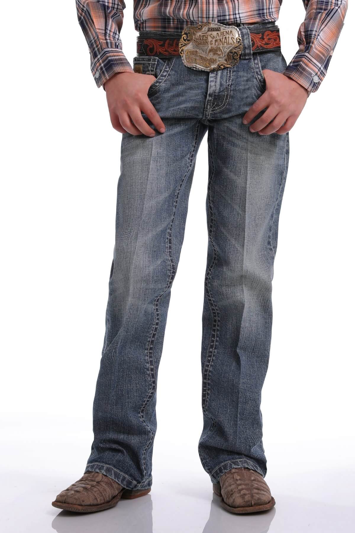 Cinch Boy's Slim Fit Jean Jeans. A boy wearing slim fit jeans with a plaid shirt and cowboy boots.