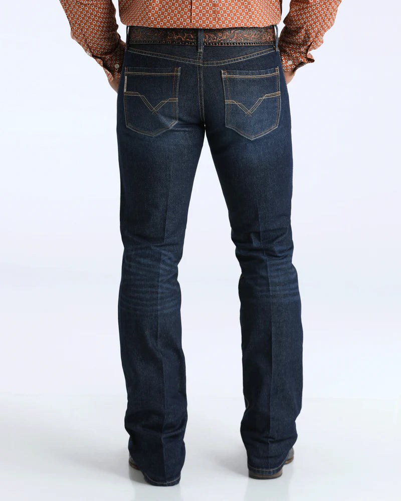 Dark blue jeans worn by a person on a white background