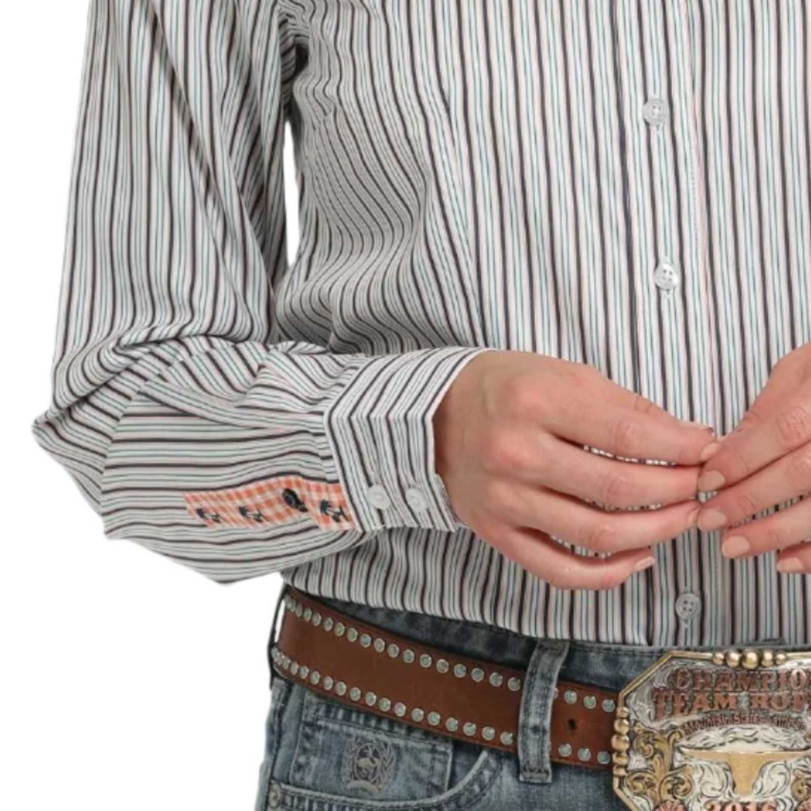 Close-up of a person wearing a striped shirt with decorative cuffs and a belt with a large buckle.