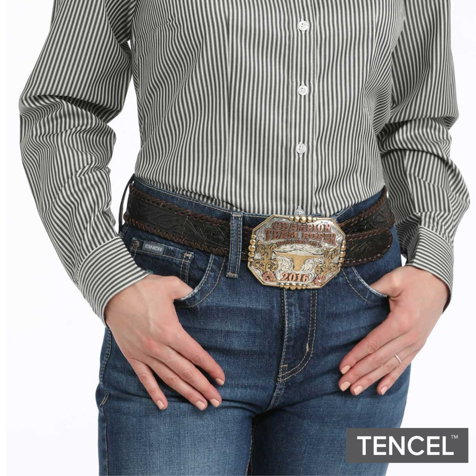 Person wearing a striped shirt, jeans, and a belt with a decorative buckle on a white background, featuring TENCEL branding.