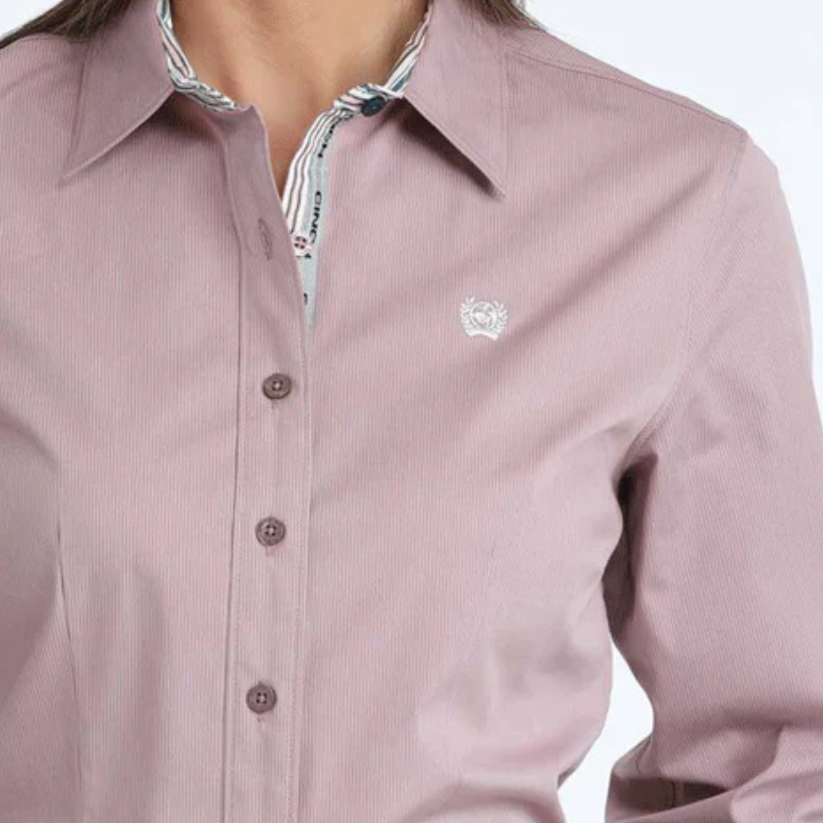 Close-up of a pink shirt with a brand logo on a white background