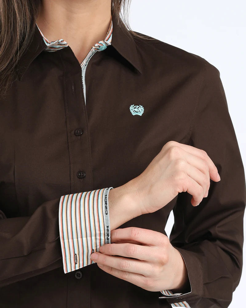 Brown shirt with striped cuffs and a small logo on a white background