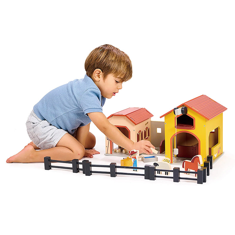 Kaleidoscope Billy's Barnyard. Child playing with a toy farm set on a white background