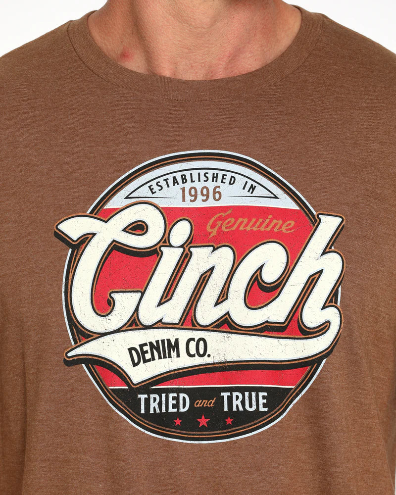 Cinch Men's Graphic T-Shirt. Brown t-shirt with Cinch Denim Co. logo on a plain background
