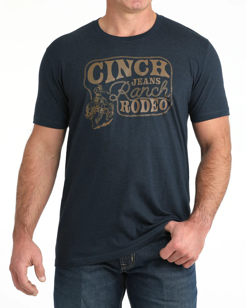 Man wearing a navy blue t-shirt with 'Cinch Jeans Ranch Rodeo' text and graphic.