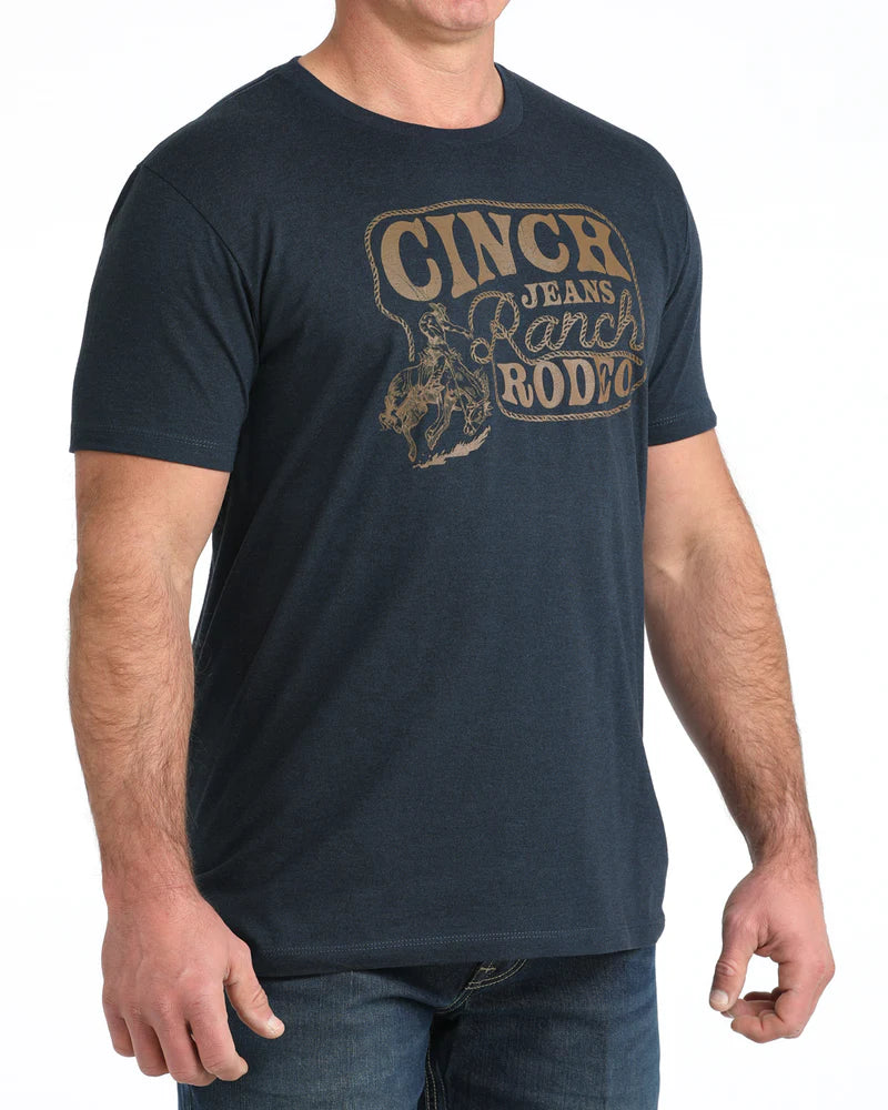 Man wearing a navy blue t-shirt with 'Cinch Jeans Ranch Rodeo' text and graphic.