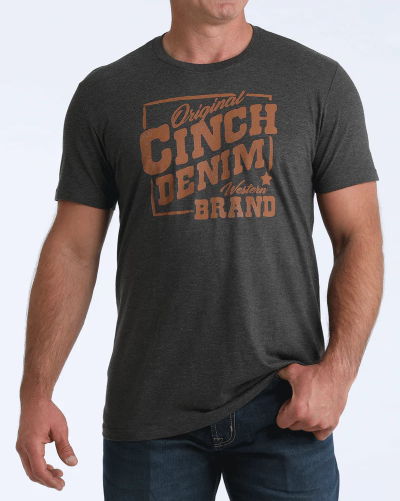 Man wearing a dark gray t-shirt with 'Original Cinch Denim Brand' text on a light gray background