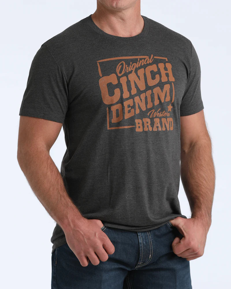 Man wearing a dark gray t-shirt with 'Original Cinch Denim Brand' text on a light gray background