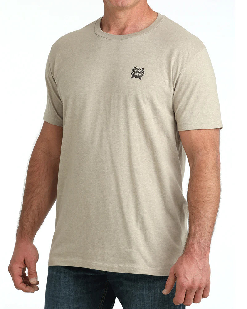 Beige t-shirt with Cinch logo on the back, worn by a person