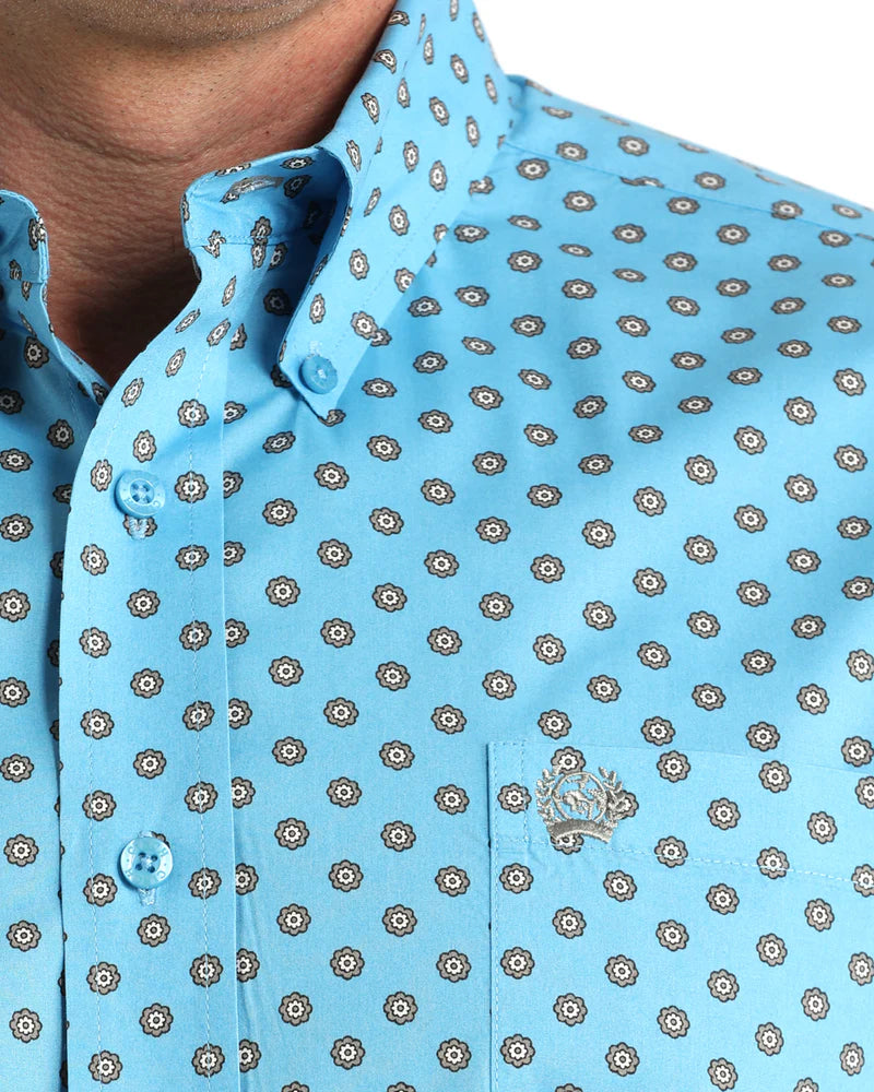 Close-up of a blue patterned shirt with a brand logo.