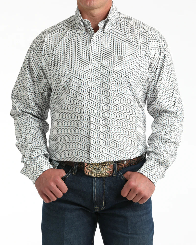 Man wearing a patterned white shirt and jeans on a white background