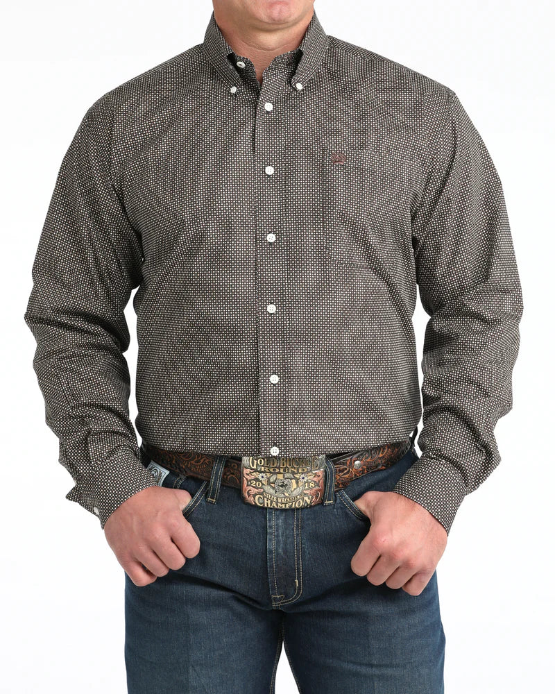Man wearing a patterned button-up shirt and jeans on a white background