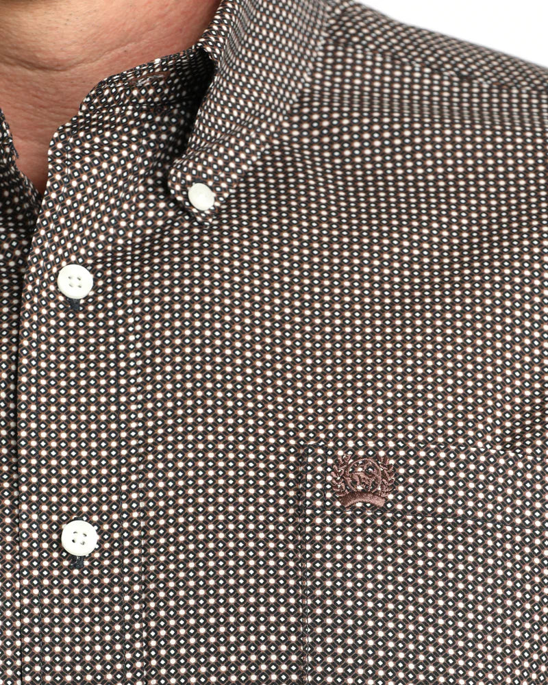 Close-up of a patterned shirt with a brand logo on a white background